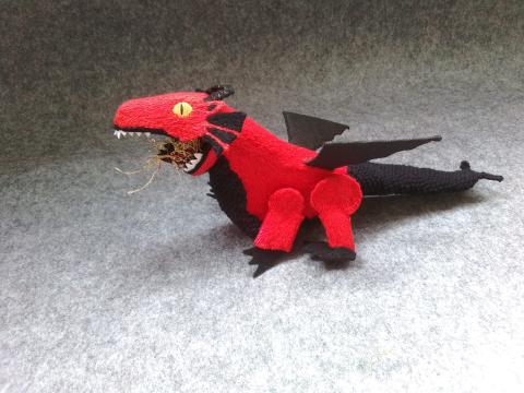 A red dragon with yellow eyes, white teeth and black wings, tail, chest and claws, is walking and breathing fire