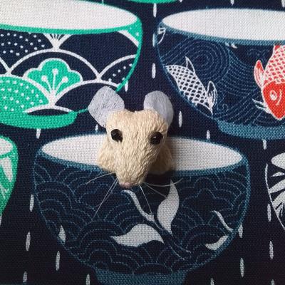 A 3D mouse peers out from a cup