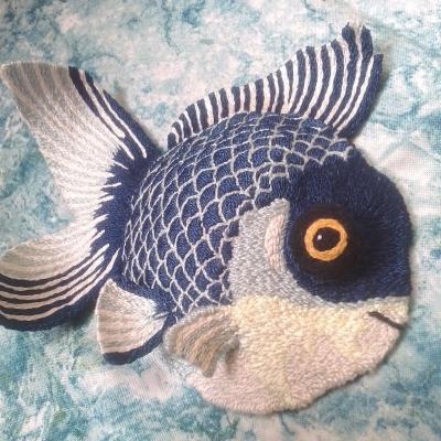A large blue fish, with dark scales, bulgy yellow and black eye and blue and white fins